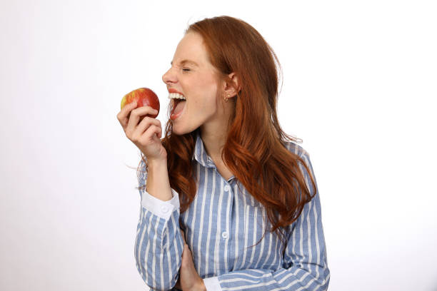istock Redhead woman in striped blouse with fruit in studio 1193737248
