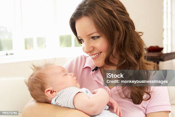 Plano Aproximado De Carinhoso Mãe Cuddling Bebé Menino Em Casa - Fotografias de stock e mais imagens de 20-29 Anos