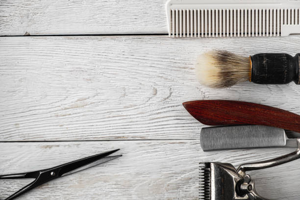 istock vintage barber tools dangerous razor hairdressing scissors old manual clipper comb shaving brush. old white weathered wood background. 1193738556