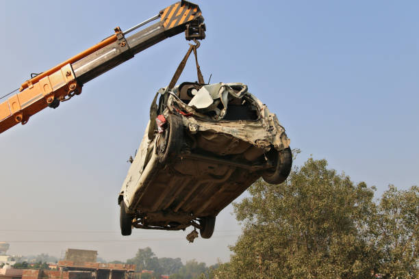 Crane lifts a broken machine for loading at the scene of an accident. Haryana, India