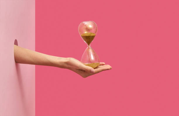 istock Sandglass on a woman's hand on a duotone background. 1193742171