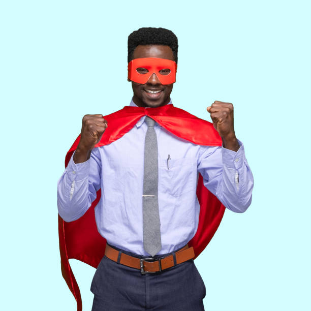 Front view / one man only / one person / waist up of handsome people curly hair / short hair generation z / african ethnicity / african-american ethnicity male / young men superhero / hero / business person / businessman standing in front of blue background / colored background wearing cape - garment / costume / eye mask / mask - disguise / button down shirt / shirt who is smiling / happy / cheerful / laughing / excited / successful / conquering adversity / cool attitude and cheering / showing fist who is and doing fist pump / courage / superman - superhero vista frontal / un hombre solamente / una persona / cintura para arriba de la gente apuestos pelo rizado / corta generación de pelo z / etnia africana / etnia afroamericana masculino / hombres jóvenes superhéroe / héroe / persona de negocios / hombre d