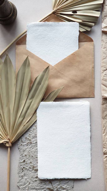 istock Blank white Wedding invitation cards mockups with dried palm leaf and craft envelope on textured table backgound. Elegant modern template for branding identity. Tropical design. Wedding stationery. Flat lay, top view 1193749455