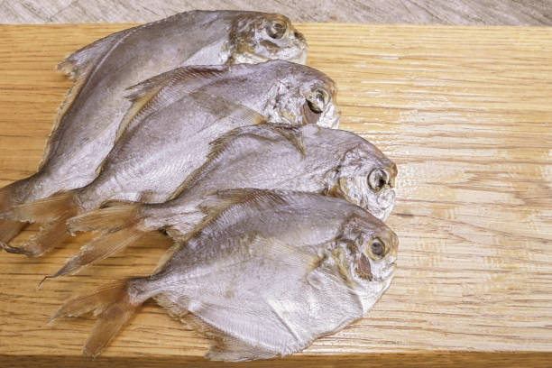 dried little piranha fish 5 pieces lies on a wooden surface. view from above dried little piranha fish 5 pieces lies on a wooden surface. view from above silver piranha fish stock pictures, royalty-free photos & images