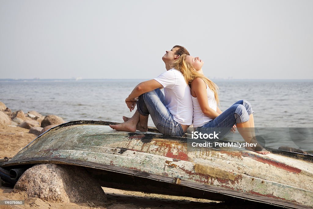 couple sitting on old boat  Adult Stock Photo