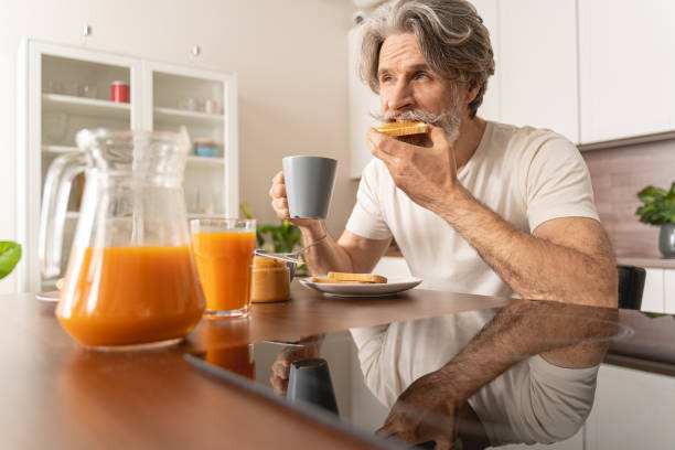 istock Serious man eating his peanut butter toast 1193752631