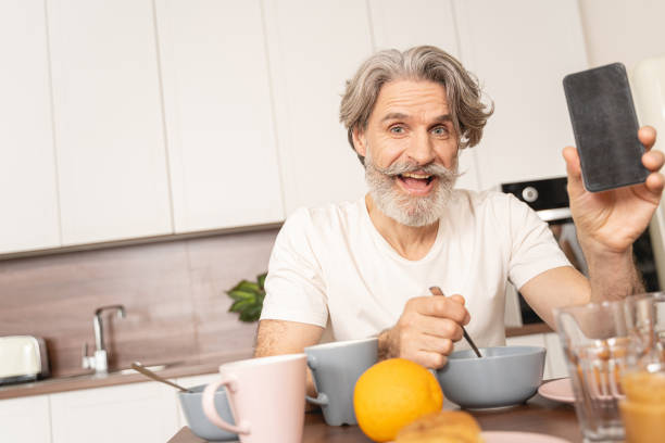 istock Cheerful male holding a gadget in his hand 1193752785