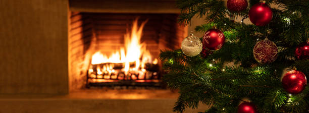 istock Christmas tree close up on burning fireplace background 1193753693