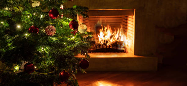 istock Christmas tree close up on burning fireplace background 1193753701