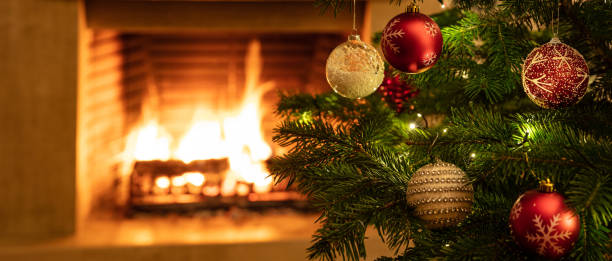 istock Christmas tree close up on burning fireplace background 1193753702
