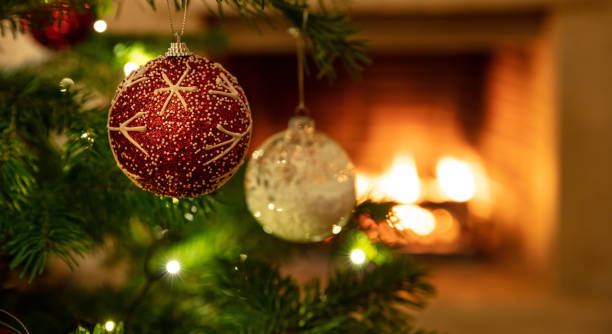 istock Christmas tree close up on burning fireplace background 1193753704