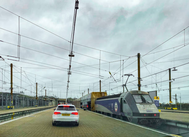 Folkestone, United Kingdom - November 28th, 2019 :  Cars driving onto the train carriage of a channel tunnel train. in preparation for its 23 mile (50Km) undersea journey to France.    Vehicle crossings each year exceed 2.6 million, and over 10 million passengers travel in this way.