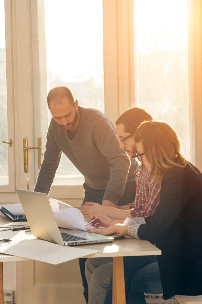 istock Group of young architects in the sunny office. 1193753974