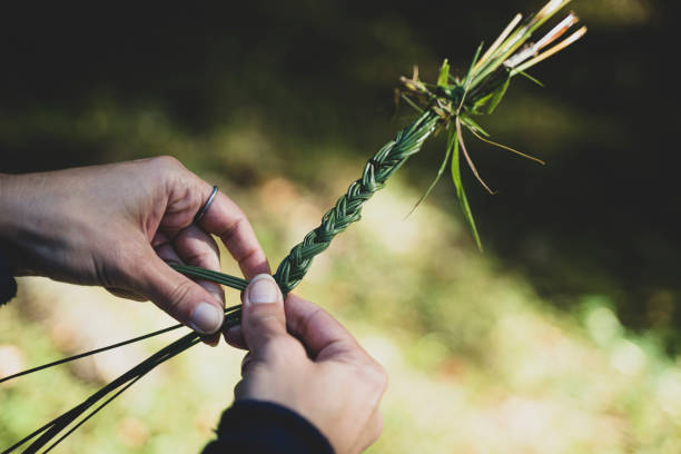 joven tejiendo una guirnalda de hierba con flores - wood rustic close up nail fotografías e imágenes de stock