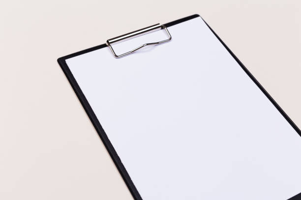 istock Clipboard with white sheet and pen on a colored background. View from above. space for text 1193757514