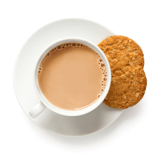 ミルクと1と半分のカリカリオート麦と全食ビスケットと紅茶のカップは、白で隔離されています。白磁。上のビュー。 - time for tea ストックフォトと画像