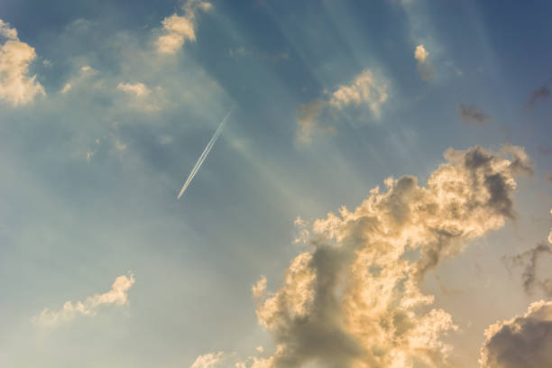 istock A high-flying passenger plane and sunbeams on a blue sky 1193760971