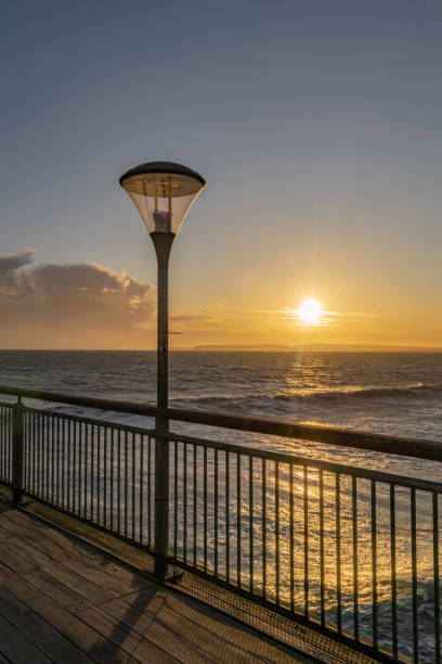 istock Sunset over Boscombe Pier, Bournemouth with lamp post and railings isolated 1193766805