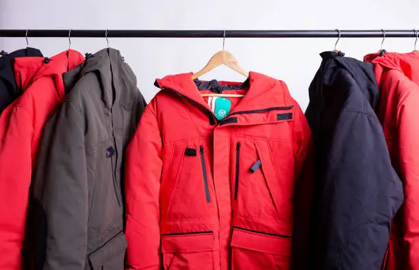 Photo of family concept or showroom of down jacket winter parka hanging on a hanger in the wardrobe