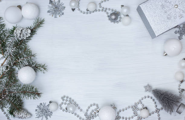 istock Christmas tree with silver gift, snowflakes, beads and white balls on light white background with copy space. Top view 1193769255