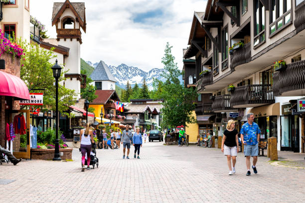 Vacation resort town of Vail, Colorado with people walking shopping by shops on Gore Creek drive Vail, USA - June 29, 2019: Vacation resort town village in Colorado with people walking shopping by shops on Gore Creek drive arthurian legend stock pictures, royalty-free photos & images