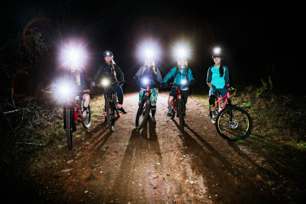 Women's Mountain Biking Club on Night Ride An all female mountain bike team enjoys a ride on some forest trails at night, equipped with bright head lamps and bike lights.   Shot in Washington State on the Olympic Peninsula. bicycle light photos stock pictures, royalty-free photos & images