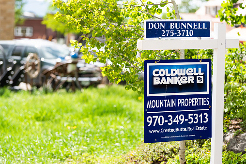 Crested Butte, USA - June 21, 2019: Colorado village downtown in summer with sign for real estate mountain property for sale