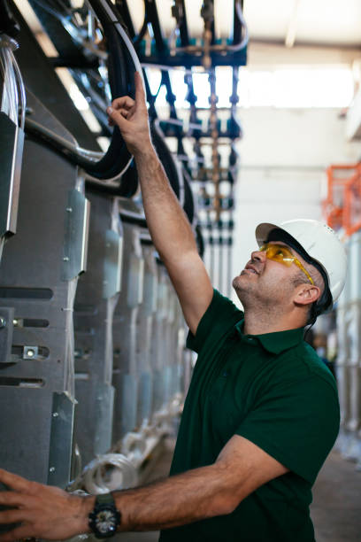 senior worker in the factory operating machines stock photo - automobile industry transportation indoors vertical imagens e fotografias de stock