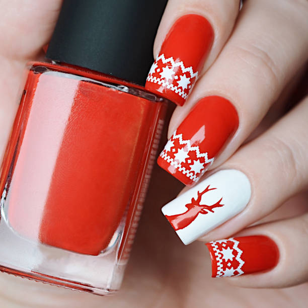 Red Christmas manicure with deer and Norwegian pattern Red Christmas manicure with deer and Norwegian patterns christmas nails stock pictures, royalty-free photos & images