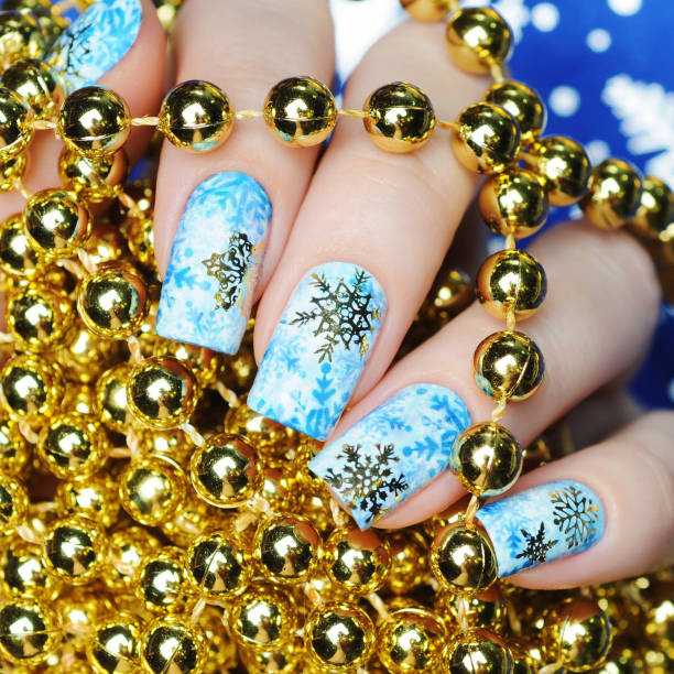 istock Christmas manicure with snowflakes on gold background 1193776077