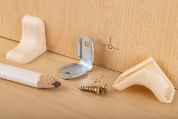 istock Mounting connectors installed to the chipboard. Carpentry work during the construction and assembly of furniture. Dark background. 1193780949