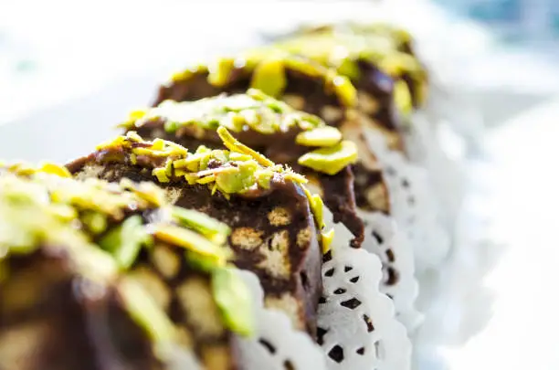 Photo of biscuit mosaic chocolate with pistachio crumbs close up