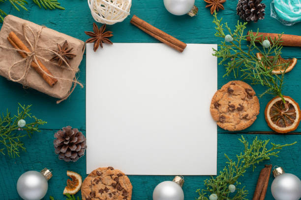 istock Christmas composition with a white blank square card and fir branches and pine cones. On a dark green wooden background, Flat lay, top view 1193789485