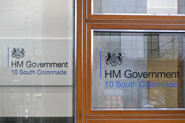 HM Government sign at wall and window London, United Kingdom - February 03, 2019: HM Government sign at their offices on 10 South Colonnade. Her Majesty's Government, is the central administration of the United Kingdom hm government stock pictures, royalty-free photos & images
