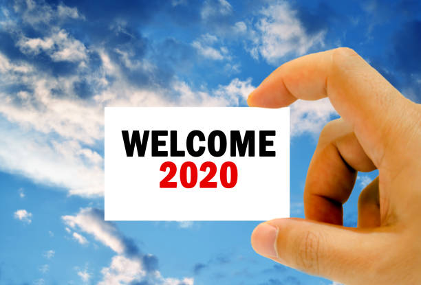 welcome 2020 on business card clouds background stock photo