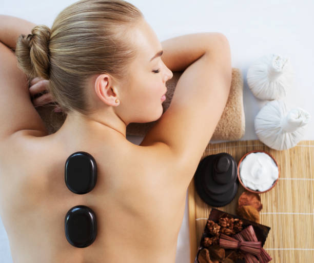 istock Woman getting hot stone massage in spa salon. 1193793608