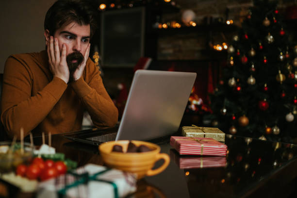 istock Worried man using laptop during Christmas holiday at home 1193796826