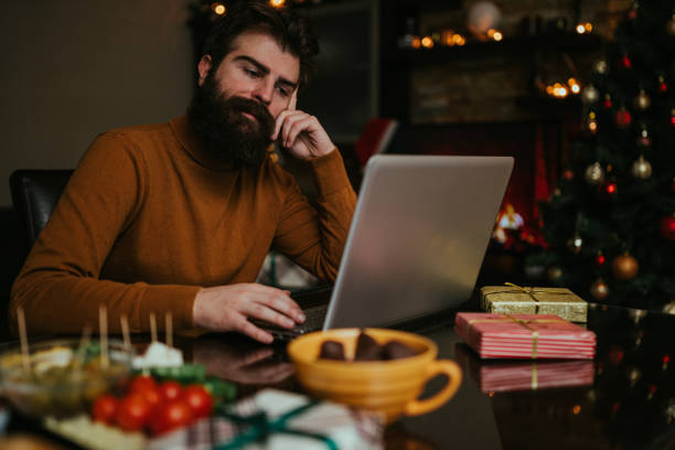 istock Worried man using laptop during Christmas holiday at home 1193796831