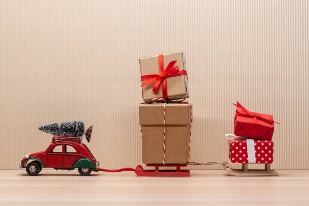 istock christmas red toy car with sledges gift fir-tree 1193801904