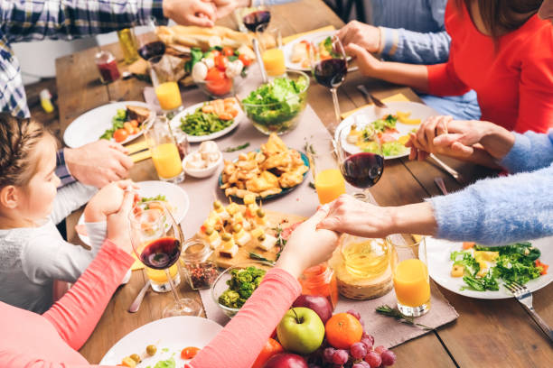 istock Family sitting at home, praying before dinner 1193802271
