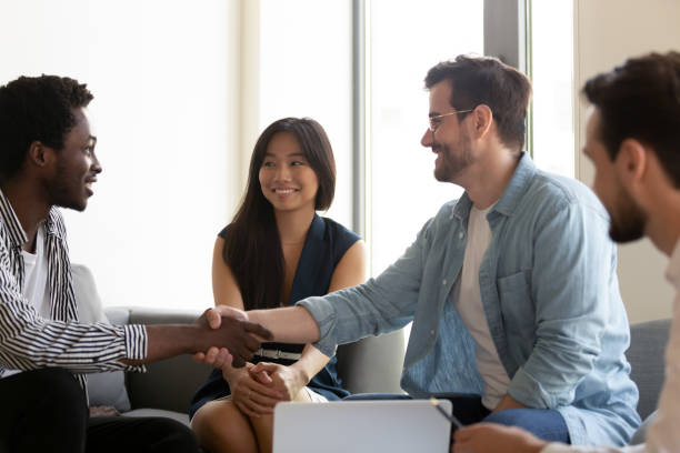 istock Smiling diverse employees handshake get acquainted in office 1193802330