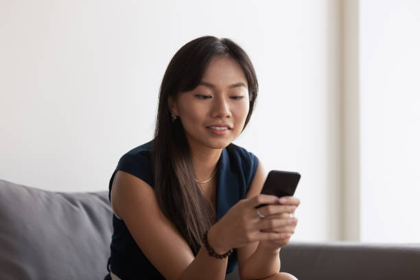 istock Asian female employee using modern cellphone in office 1193802339