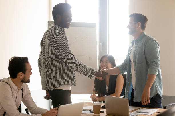 istock Smiling multiethnic male employees handshake at briefing 1193802367