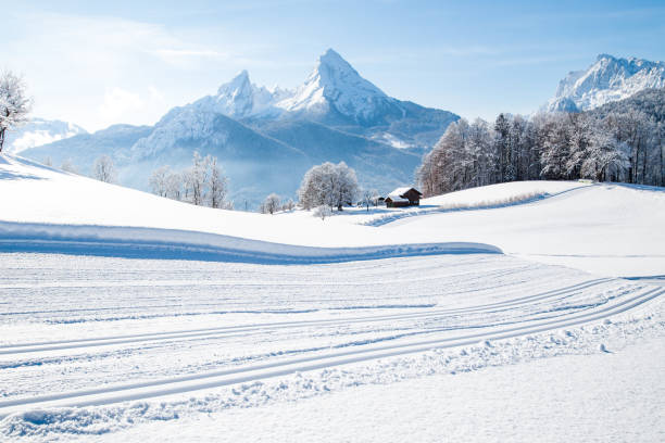 Winter wonderland scenery with cross-country skiing track in the Alps Beautiful winter wonderland mountain scenery in the Alps with cross country skiing track on a scenic cold sunny day with blue sky and clouds switzerland photos stock pictures, royalty-free photos & images