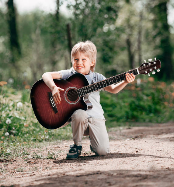 istock little boy with guitar on the Boulevard in the Park 1193815982