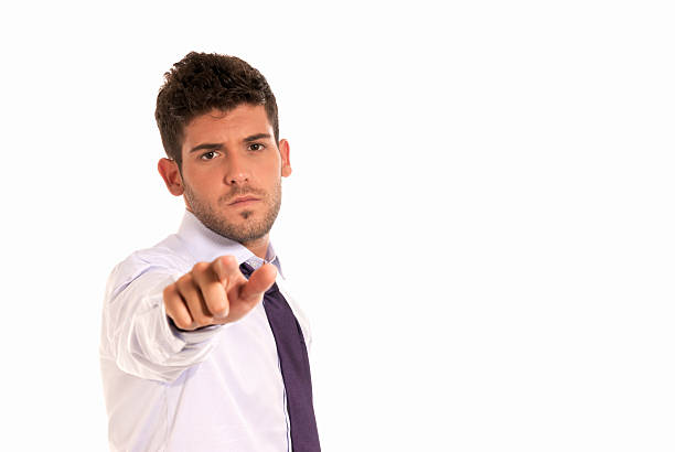 young businessman pointing to camera with copy-space isolated stock photo