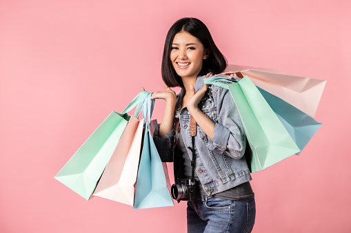 Tourist woman in summer casual clothes.Asian Smiling woman .Passenger traveling and shopping on pink background.She going to summer vacation.Travel trip funny  on holiday.