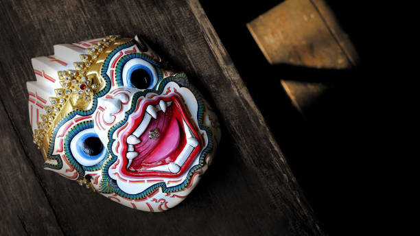 Thai traditional Hanuman actor's mask on table top Top view of Thai traditional Hanuman actor's mask( Khon mask) on wooden table with blurred sunlight and shadow on wooden floor background. This actor's mask used for pantomime practicing ramayana stock pictures, royalty-free photos & images