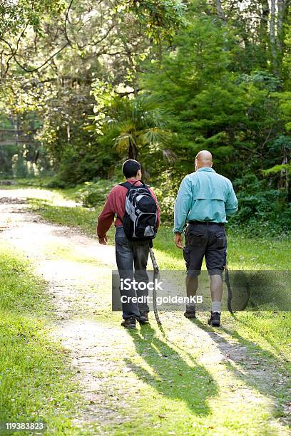 Rear View Father And Son Hiking In Woods On Trail Stock Photo - Download Image Now - Footpath, Teenager, 14-15 Years