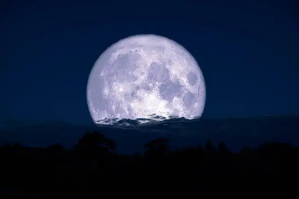 Photo of super milk moon back on silhouette mountain on night sky